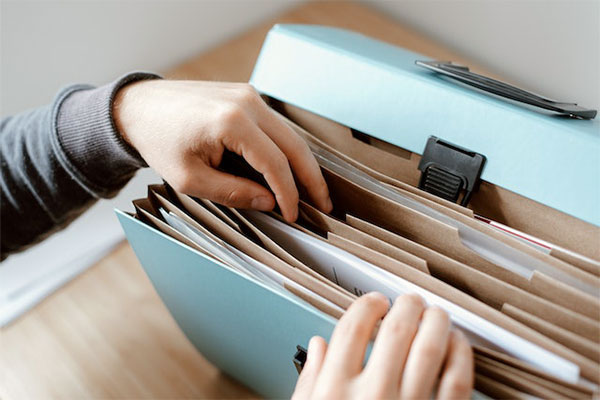 Hands going through files looking for paperwork