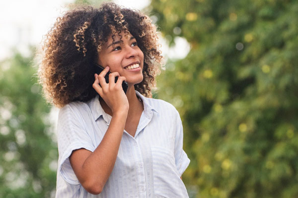 young woman on phone in the woods