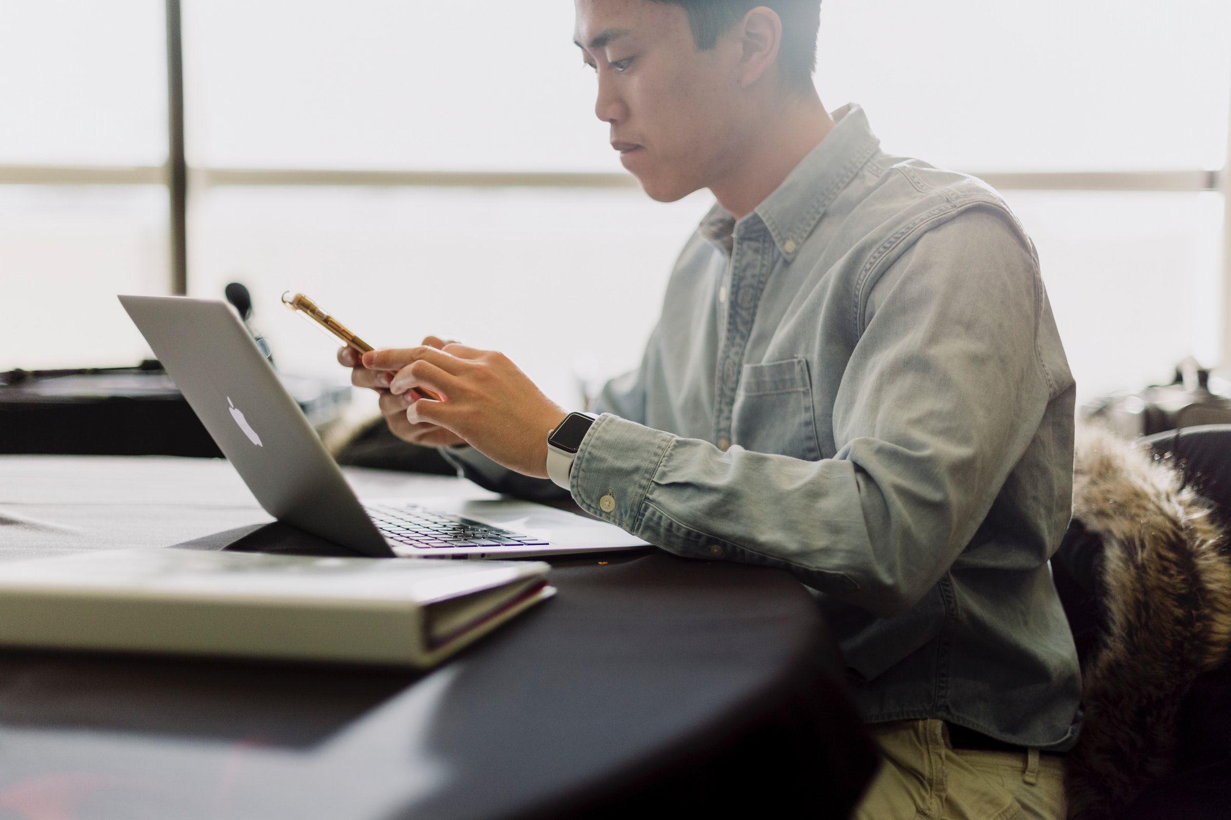 A person looking at a laptop and cell phone
