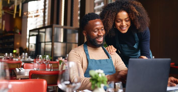 Restaurant owners looking at a laptop together