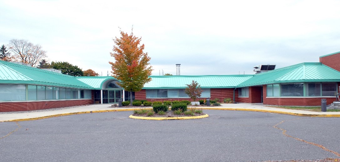 The exterior of a single story office building with a blue roof