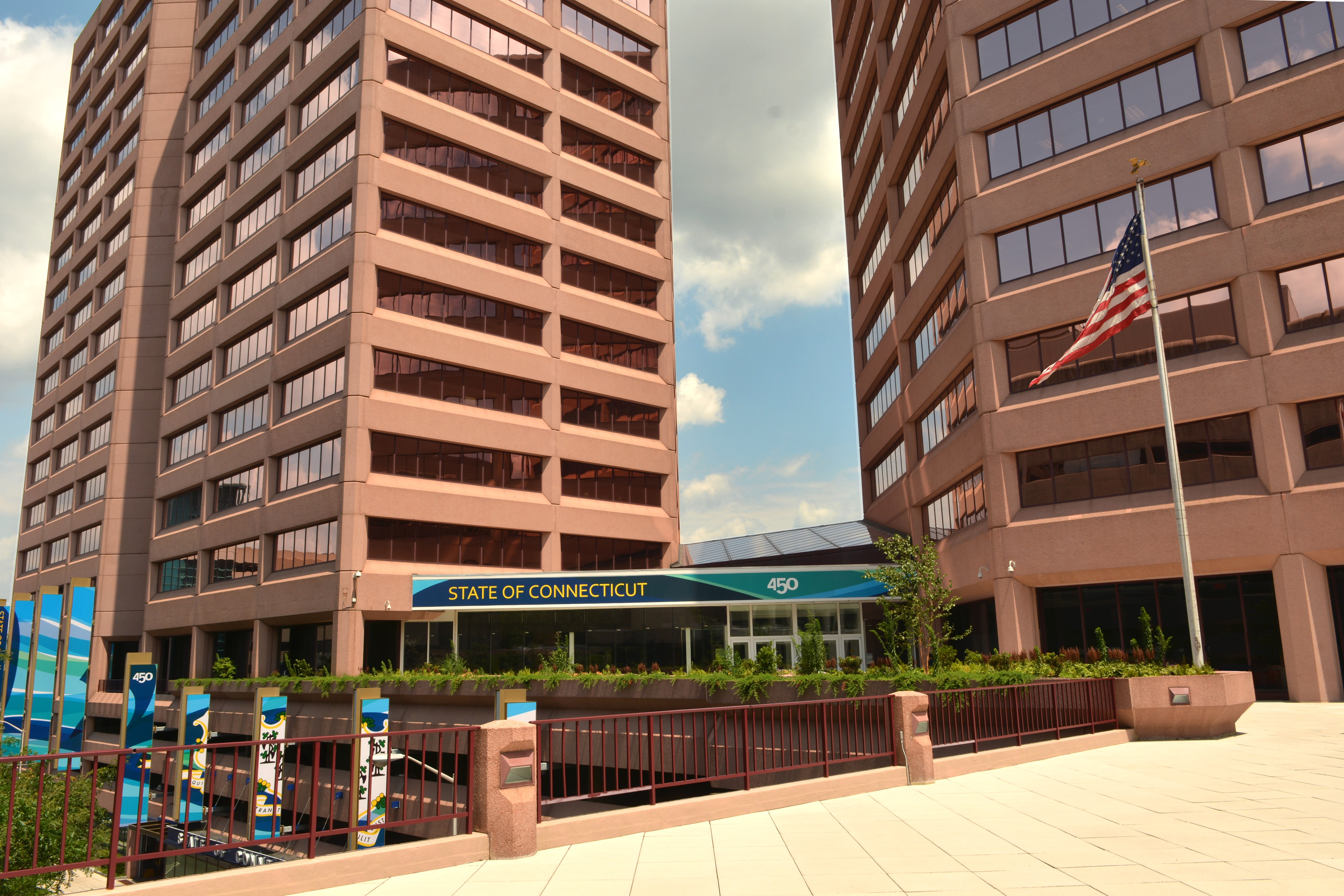 The exterior of an office building with two towers. The sign in front reads "state of Connecticut"
