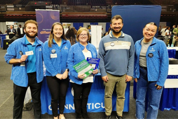 A group of people at a job fair pose for a photo