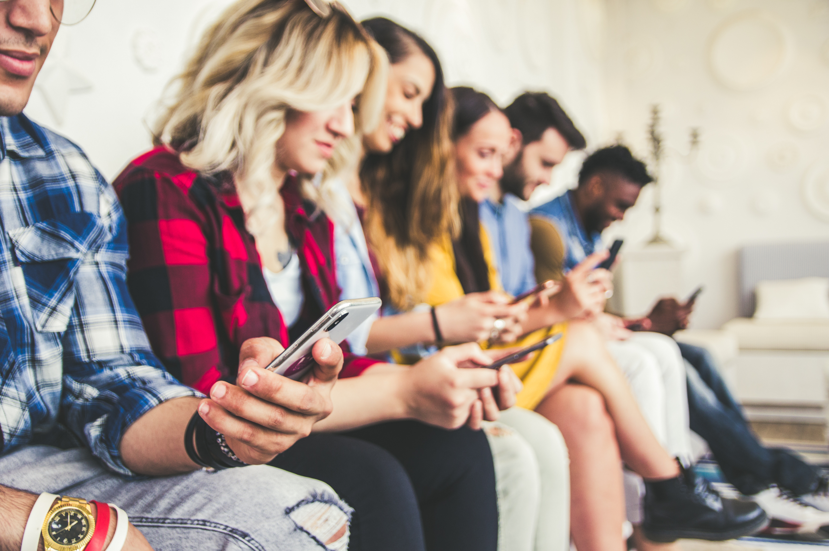 A stock image of several people reading something on their cell phones.