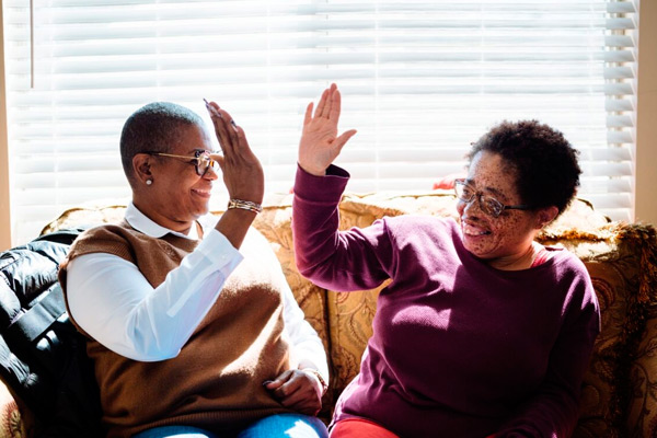 two individuals high-fiving and smiling