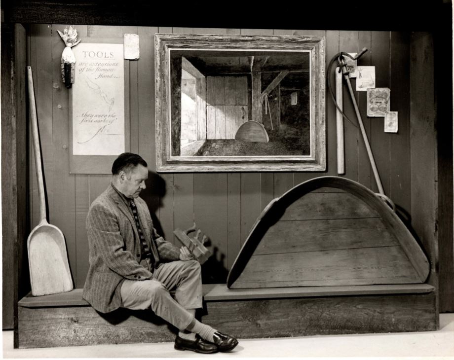 Eric Sloane sitting on a bench in a museum exhibit