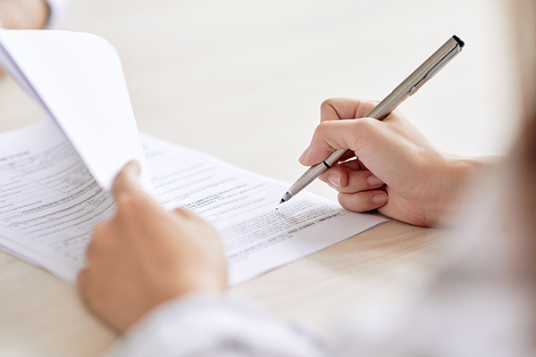 Person filling out forms.