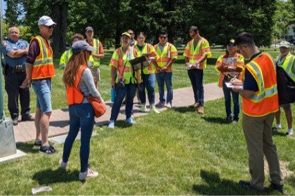 Multiple people gathered outside in safety vests conducting road safety audits