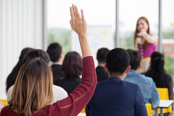 Women raising hand during meeting