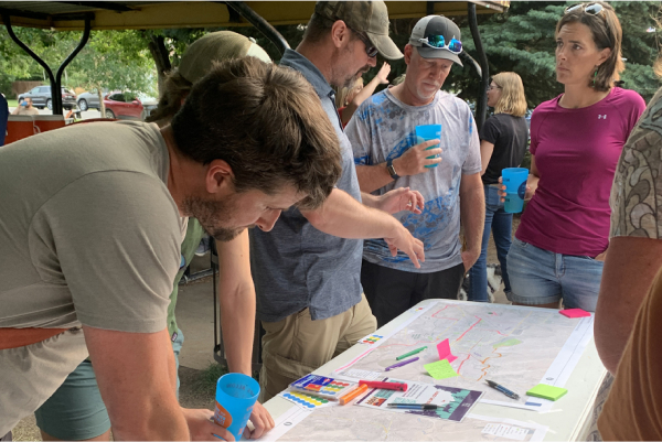 People examining an information table.