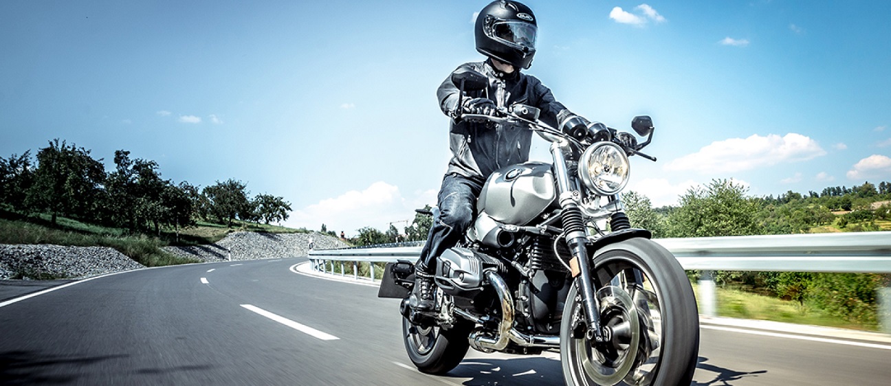 biker riding motorcycle with helmet and gloves