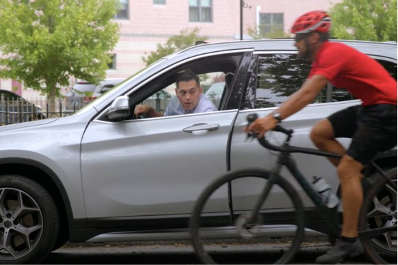 driver opening car door carefully as a cyclist passes by 