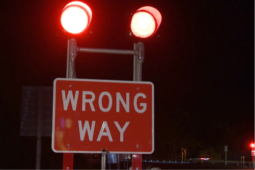 red wrong way sign with red lights