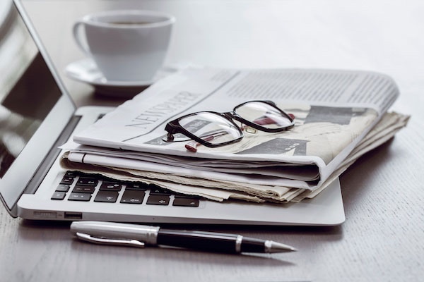 laptop, newspaper, and sunglasses