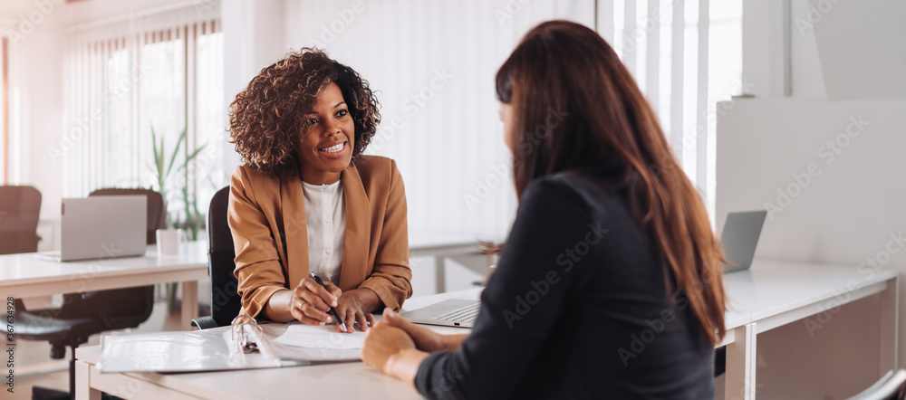 two woman in an office going over paper work 