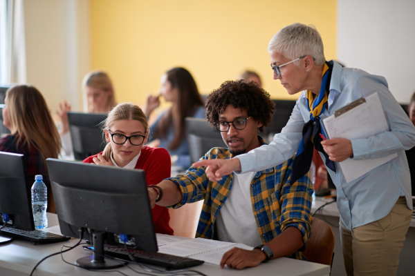 Professor helping students learn on their computer