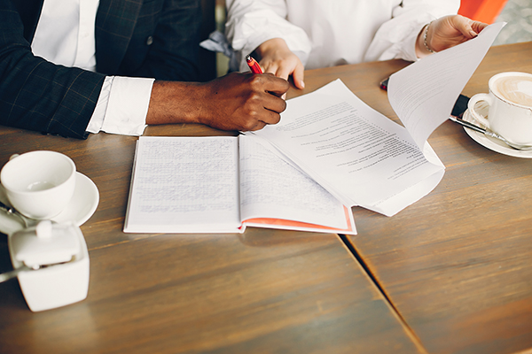 Two people in a meeting reviewing documents.