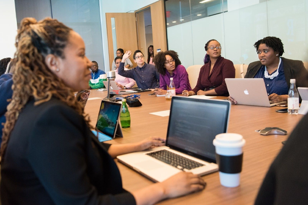 group of educators with laptops sitting around a meeting table