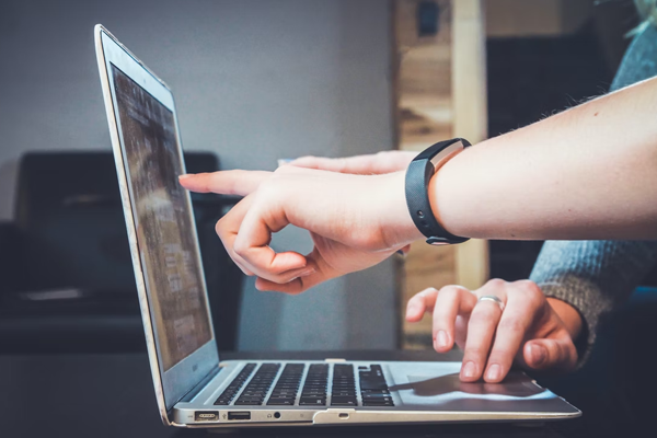 Two people using a laptop computer