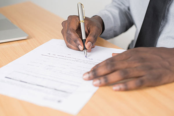 black male hands writing with pen
