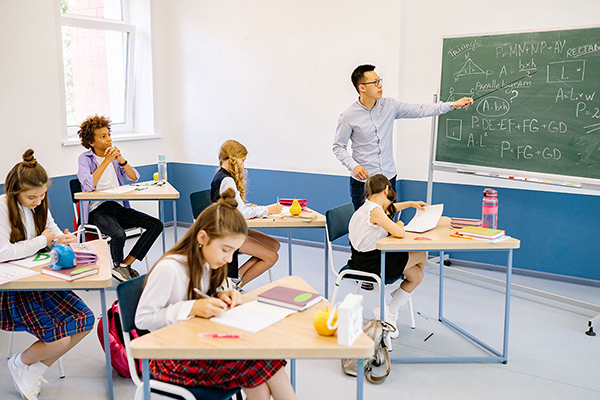 elementary school teacher with students in classroom